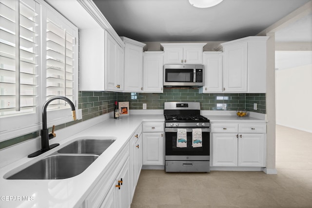5325 Timberwolf Dr, El Paso, TX 79903 - kitchen featuring stainless steel appliances, a sink, white cabinets, and backsplash
