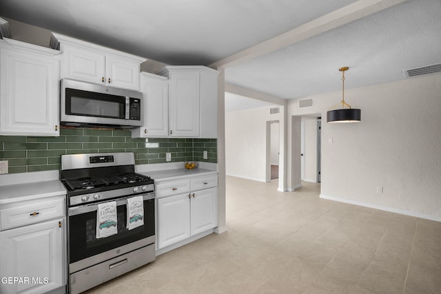 5325 Timberwolf Dr, El Paso, TX 79903 - kitchen featuring stainless steel appliances, backsplash, light countertops, and white cabinetry