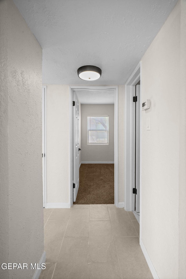 5325 Timberwolf Dr, El Paso, TX 79903 - corridor with a textured ceiling, baseboards, tile patterned floors, and carpet floors