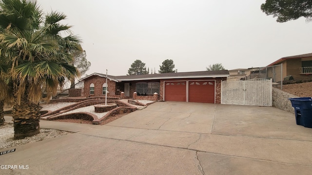 1523 Vista Real Dr, El Paso, TX 79935 - view of front facade featuring brick siding, a garage, a gate, and concrete driveway