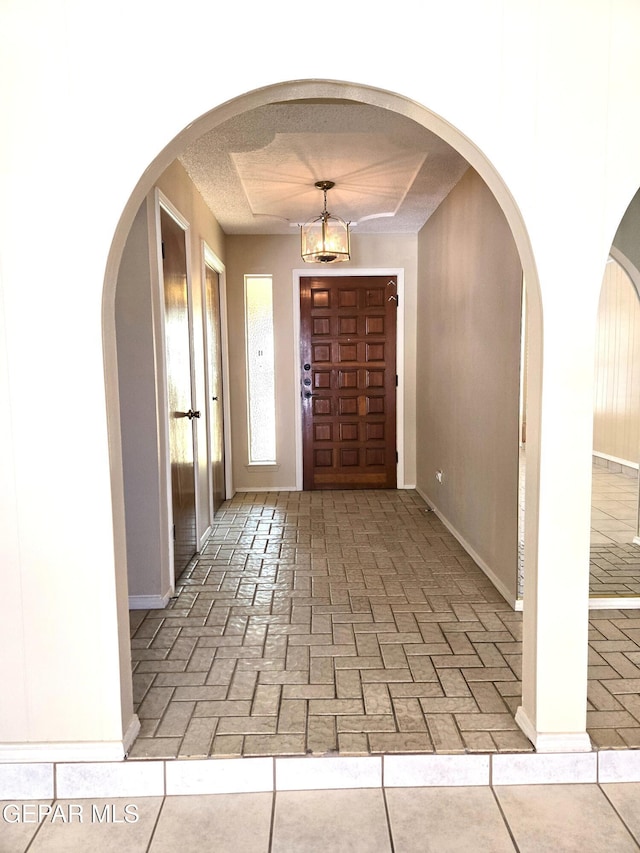 foyer entrance with brick floors and arched walkways