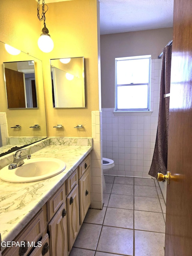 full bath with tile walls, tile patterned floors, vanity, toilet, and a shower with curtain