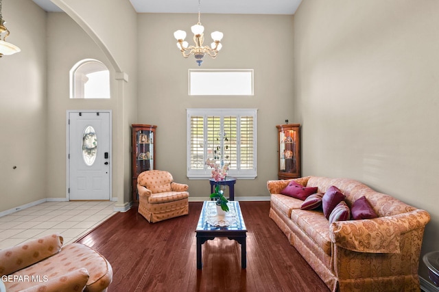 421 Wild Willow Dr, El Paso, TX 79922 - living area with a chandelier, a towering ceiling, baseboards, wood finished floors, and arched walkways