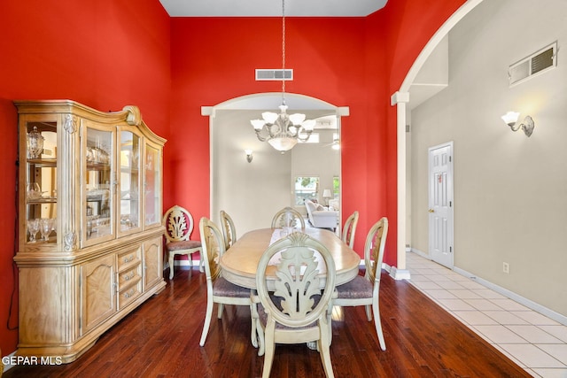 421 Wild Willow Dr, El Paso, TX 79922 - dining area with a chandelier, a towering ceiling, wood finished floors, arched walkways, and baseboards