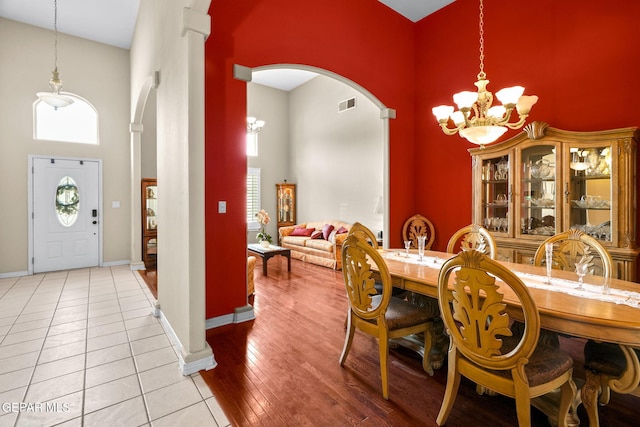 421 Wild Willow Dr, El Paso, TX 79922 - dining area featuring a towering ceiling, a chandelier, baseboards, arched walkways, and decorative columns