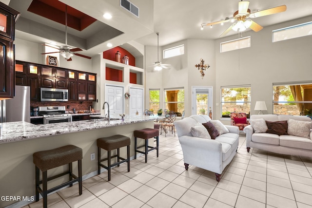 421 Wild Willow Dr, El Paso, TX 79922 - living area featuring a ceiling fan, a towering ceiling, and light tile patterned floors