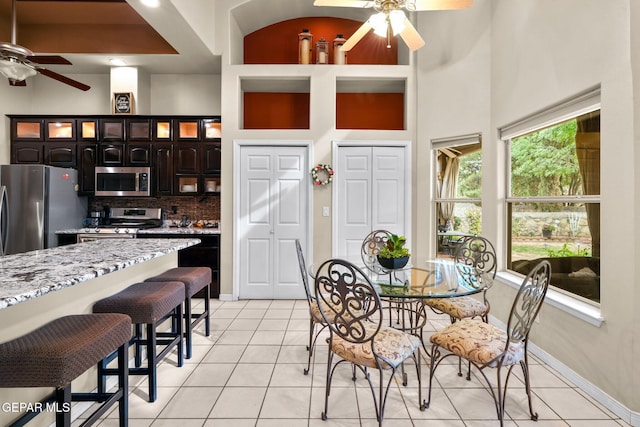 421 Wild Willow Dr, El Paso, TX 79922 - dining space with ceiling fan, light tile patterned floors, a high ceiling, and baseboards