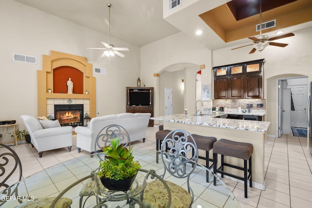 421 Wild Willow Dr, El Paso, TX 79922 - kitchen featuring a ceiling fan, arched walkways, a towering ceiling, a sink, and a breakfast bar