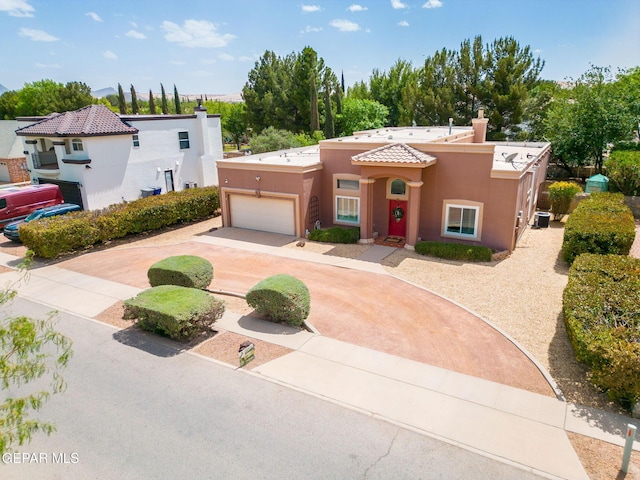 421 Wild Willow Dr, El Paso, TX 79922 - view of front facade featuring driveway, stucco siding, a chimney, a garage, and a tiled roof