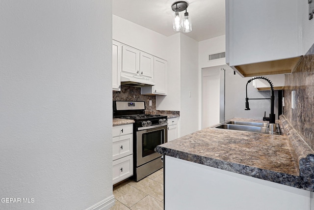 4540 Swan Dr, El Paso, TX 79922 - kitchen with stainless steel range with gas stovetop, under cabinet range hood, a sink, decorative backsplash, and white cabinets