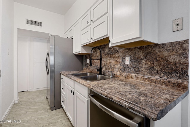 4540 Swan Dr, El Paso, TX 79922 - kitchen with stainless steel dishwasher, a sink, backsplash, and white cabinetry