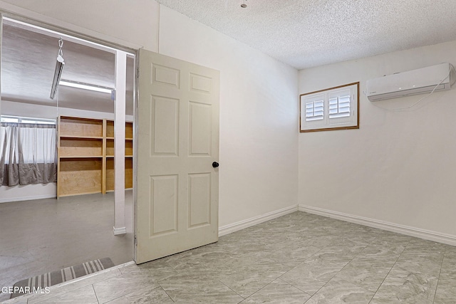 4540 Swan Dr, El Paso, TX 79922 - unfurnished room featuring a wall unit AC, a textured ceiling, baseboards, and marble finish flooring