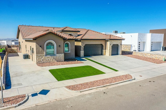 309 Blue Vly, El Paso, TX 79928 - mediterranean / spanish home featuring stone siding, stucco siding, a tile roof, and an attached garage