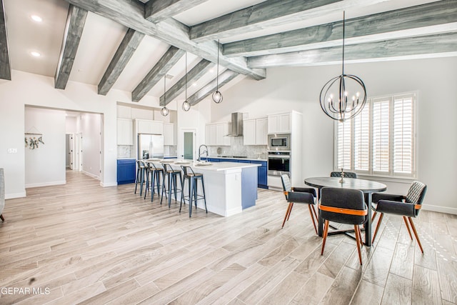 309 Blue Vly, El Paso, TX 79928 - kitchen with wall chimney range hood, stainless steel appliances, light countertops, a center island with sink, and backsplash