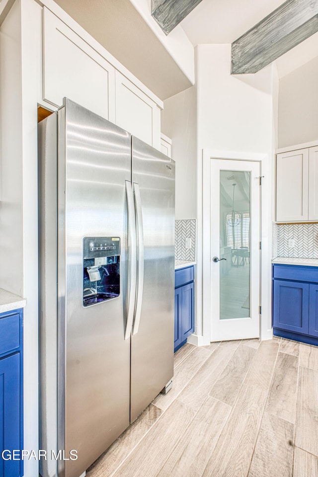 309 Blue Vly, El Paso, TX 79928 - kitchen featuring stainless steel fridge with ice dispenser, backsplash, light countertops, and blue cabinetry