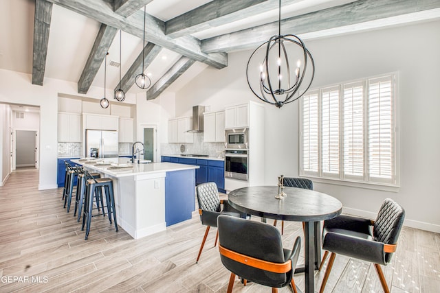 309 Blue Vly, El Paso, TX 79928 - dining room with beam ceiling, a chandelier, baseboards, healthy amount of natural light, and light wood-style flooring