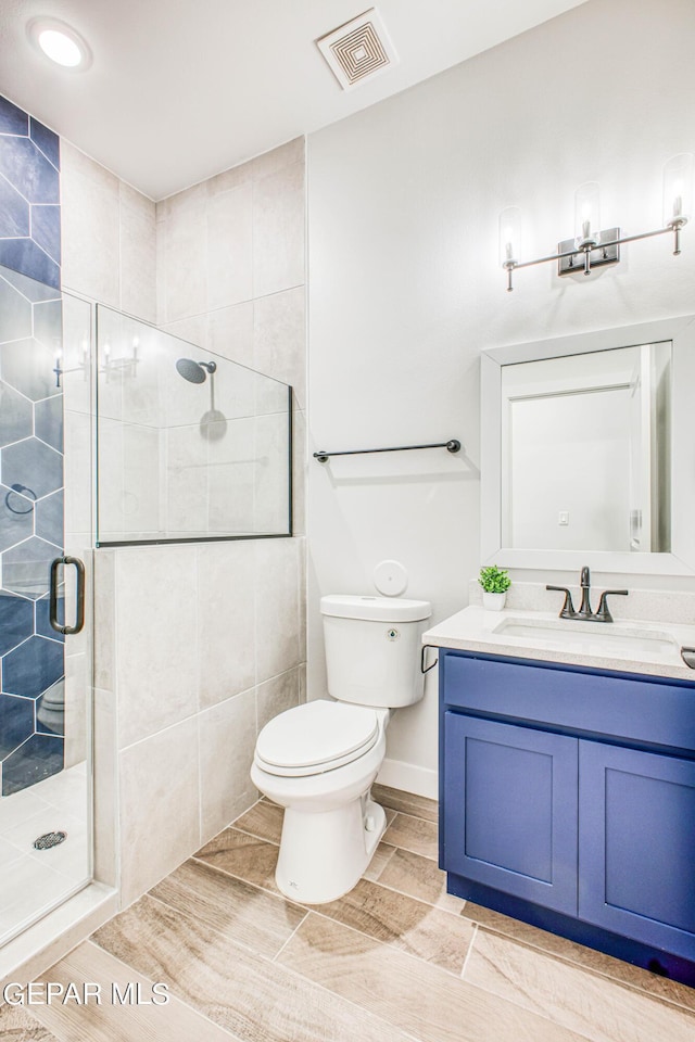 309 Blue Vly, El Paso, TX 79928 - bathroom with a shower stall, toilet, vanity, and wood finished floors