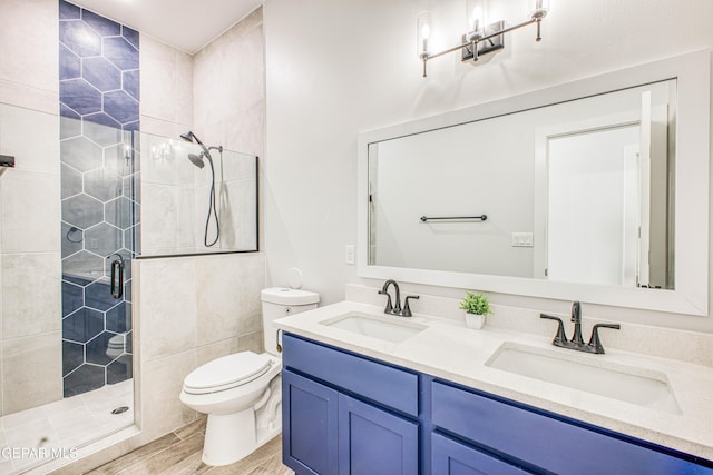 309 Blue Vly, El Paso, TX 79928 - bathroom with a stall shower, toilet, wood finished floors, and double vanity