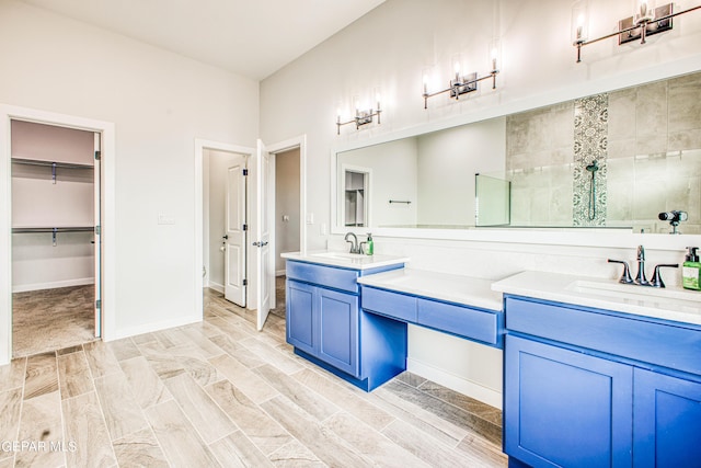 309 Blue Vly, El Paso, TX 79928 - bathroom with double vanity, a tile shower, wood finished floors, and baseboards