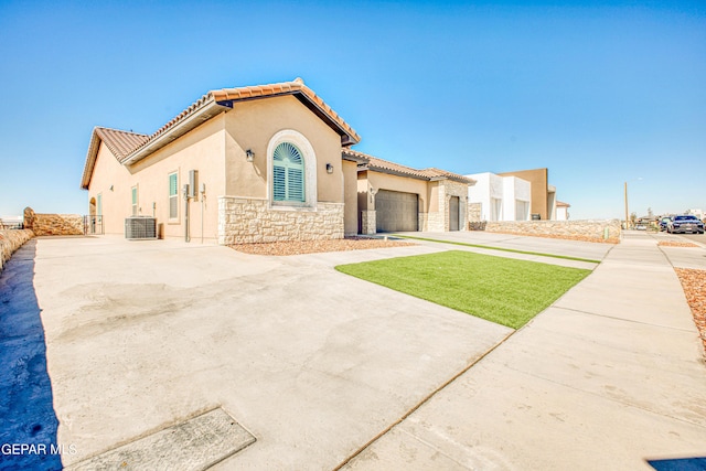309 Blue Vly, El Paso, TX 79928 - mediterranean / spanish-style house featuring stone siding, stucco siding, a tiled roof, an attached garage, and cooling unit