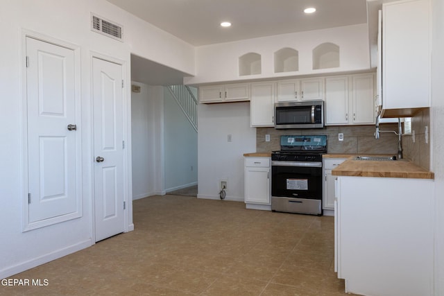 10793 Blue Sage Cir, El Paso, TX 79924 - kitchen featuring appliances with stainless steel finishes, a sink, tasteful backsplash, white cabinets, and butcher block countertops