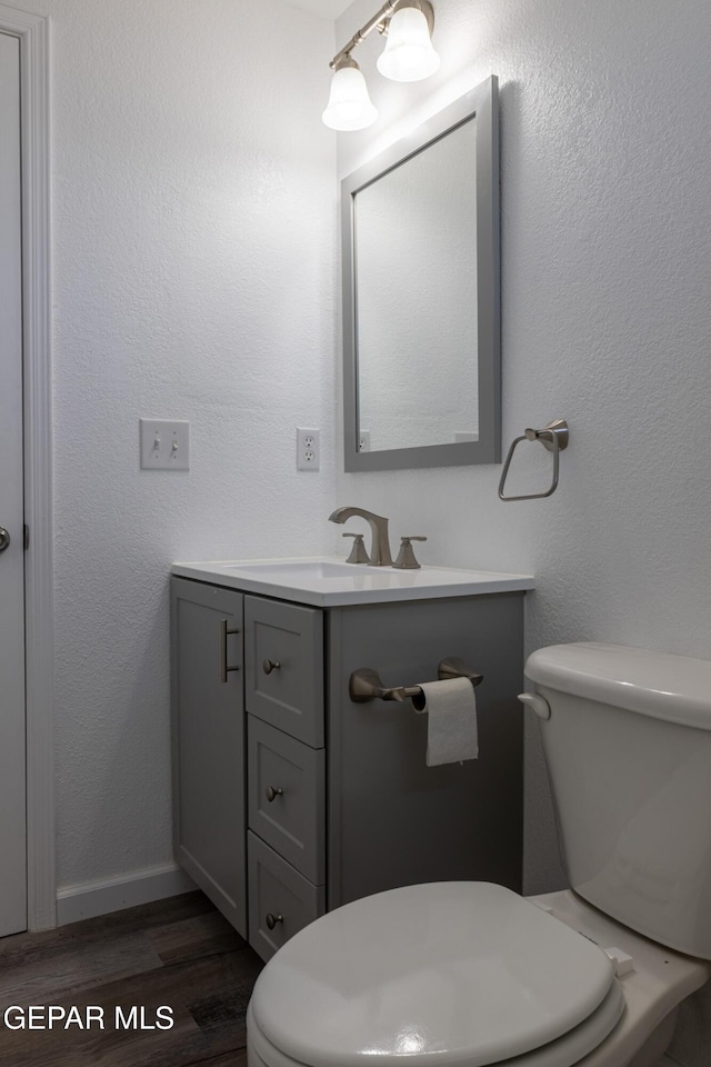 10793 Blue Sage Cir, El Paso, TX 79924 - bathroom with toilet, wood finished floors, vanity, and baseboards
