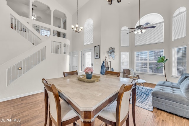 3208 Cascade Point Dr, El Paso, TX 79938 - dining area featuring ceiling fan, a towering ceiling, stairway, light wood-type flooring, and baseboards