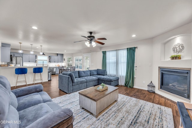 3208 Cascade Point Dr, El Paso, TX 79938 - living room featuring a ceiling fan, wood finished floors, recessed lighting, a glass covered fireplace, and baseboards