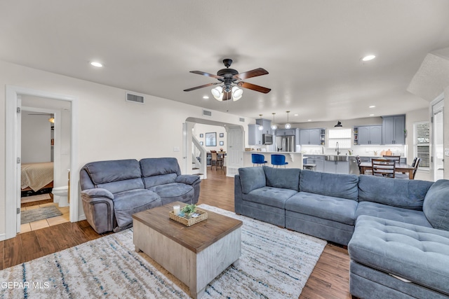 3208 Cascade Point Dr, El Paso, TX 79938 - living area with a ceiling fan, dark wood-type flooring, arched walkways, stairway, and recessed lighting