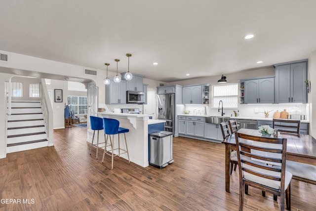 3208 Cascade Point Dr, El Paso, TX 79938 - kitchen featuring appliances with stainless steel finishes, open shelves, a breakfast bar area, a peninsula, and tasteful backsplash