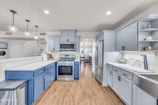 3208 Cascade Point Dr, El Paso, TX 79938 - kitchen featuring appliances with stainless steel finishes, blue cabinetry, open shelves, backsplash, and recessed lighting