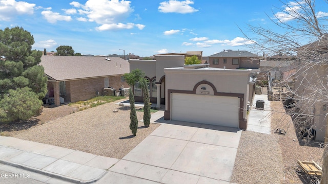 southwest-style home with concrete driveway, an attached garage, and stucco siding