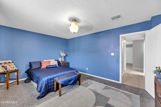 carpeted bedroom with baseboards, tile patterned flooring, a textured ceiling, and ceiling fan