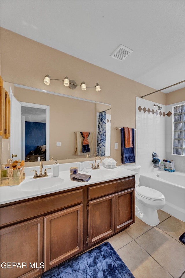 bathroom featuring tile patterned floors, toilet, double vanity, and bathing tub / shower combination