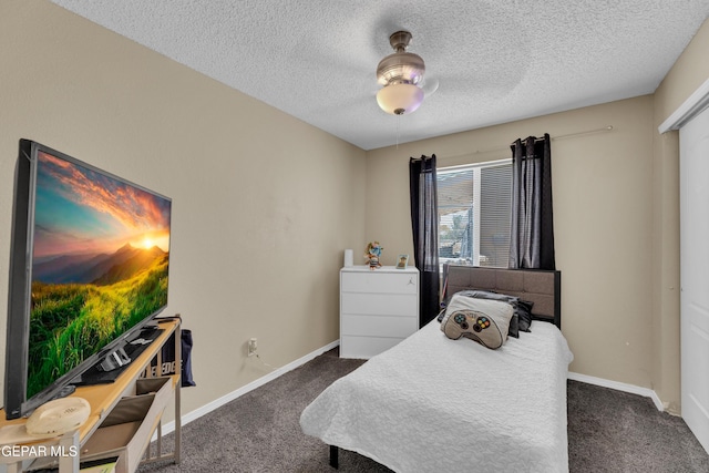 bedroom with dark carpet, a textured ceiling, baseboards, and ceiling fan