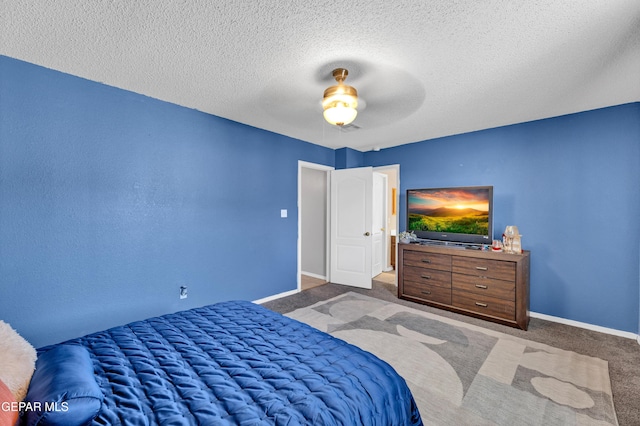 bedroom with carpet, a textured ceiling, baseboards, and ceiling fan