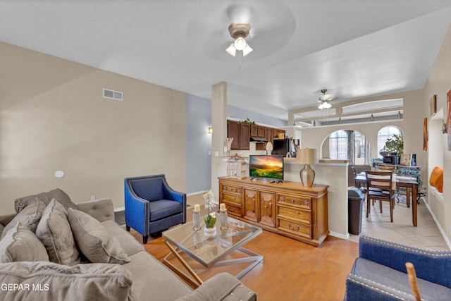 living room featuring a ceiling fan and baseboards