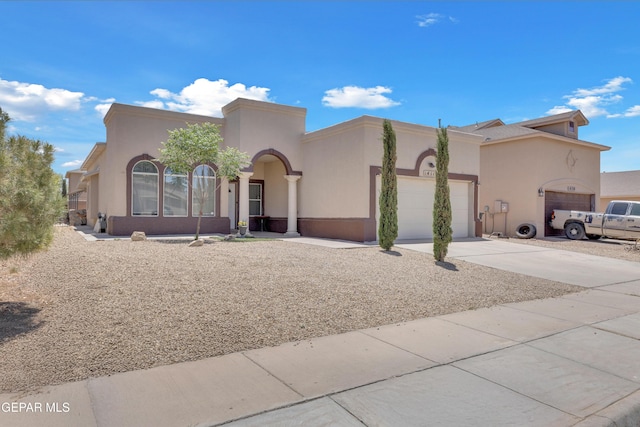 mediterranean / spanish-style house with a garage, driveway, and stucco siding