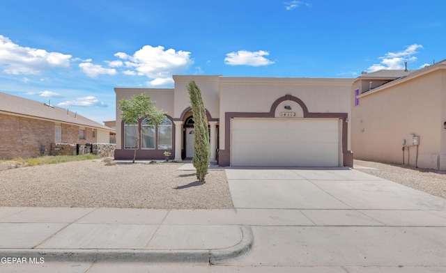 southwest-style home with an attached garage, driveway, and stucco siding