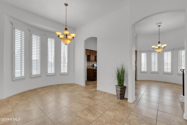 3165 Diego Aidan Dr, El Paso, TX 79938 - unfurnished dining area featuring a chandelier, arched walkways, healthy amount of natural light, and light tile patterned floors