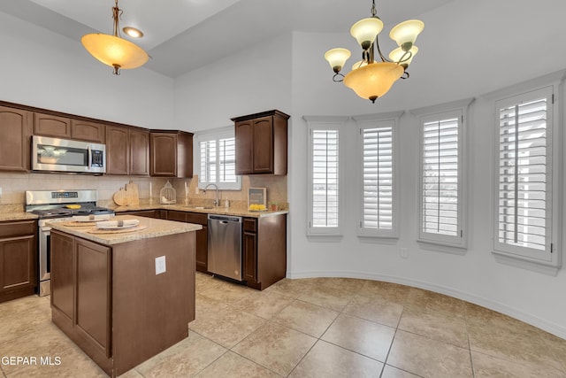 3165 Diego Aidan Dr, El Paso, TX 79938 - kitchen with appliances with stainless steel finishes, a sink, a high ceiling, decorative backsplash, and light stone counters