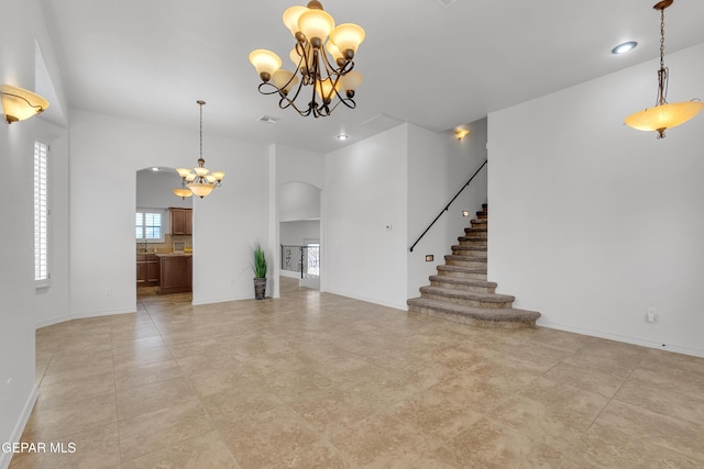 3165 Diego Aidan Dr, El Paso, TX 79938 - unfurnished living room featuring a chandelier, arched walkways, stairs, baseboards, and recessed lighting