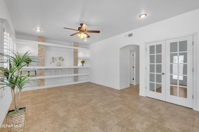 3165 Diego Aidan Dr, El Paso, TX 79938 - empty room featuring arched walkways, built in shelves, a ceiling fan, french doors, and recessed lighting