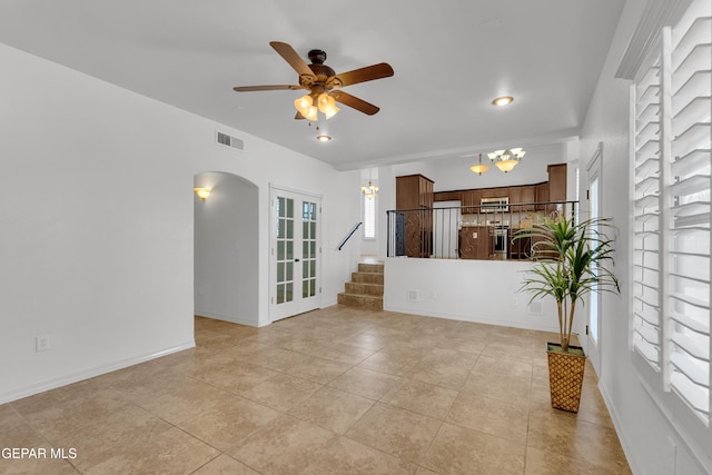 3165 Diego Aidan Dr, El Paso, TX 79938 - unfurnished living room featuring a chandelier, stairway, arched walkways, ceiling fan, and light tile patterned floors