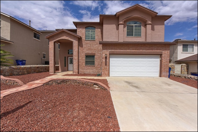 view of front of house featuring driveway, a garage, and brick siding