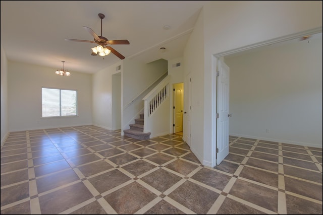 spare room featuring stairway, a chandelier, a ceiling fan, and baseboards