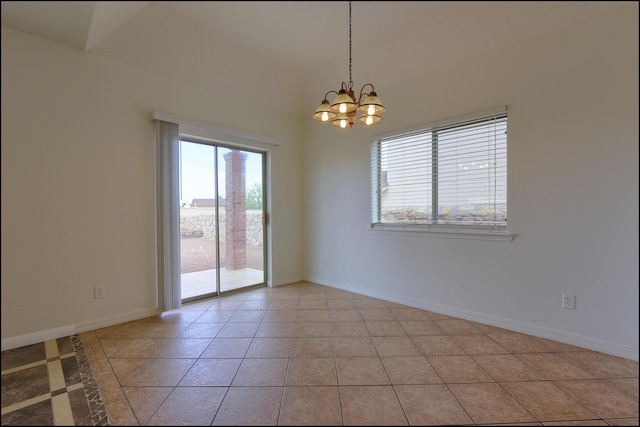 spare room with a chandelier, light tile patterned floors, and baseboards