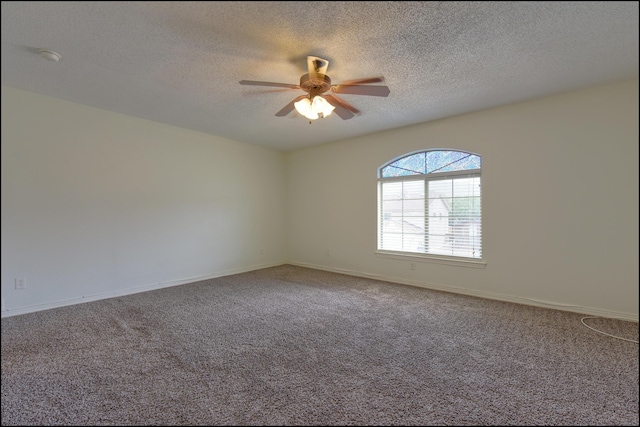 carpeted spare room featuring ceiling fan, a textured ceiling, and baseboards