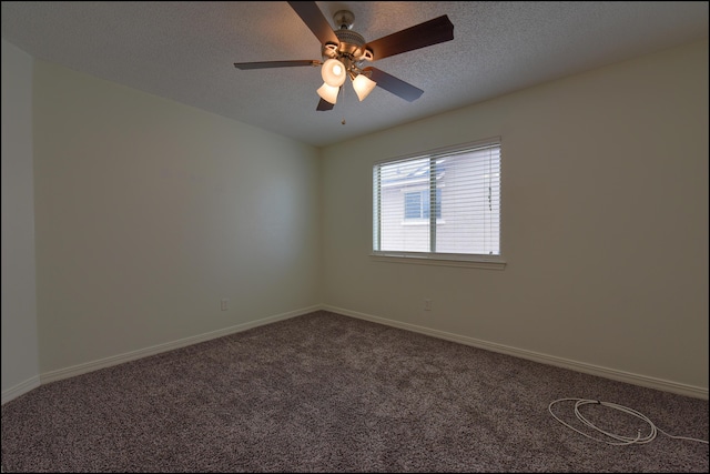 spare room with dark colored carpet, ceiling fan, baseboards, and a textured ceiling