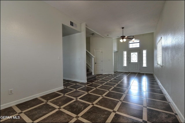 1493 Luz De Sol Dr, El Paso, TX 79912 - foyer entrance featuring stairway, inlaid floor details, baseboards, a ceiling fan, and a towering ceiling